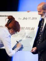 Two people holding a jumbo size check at a ceremony at Gaulladet Collge